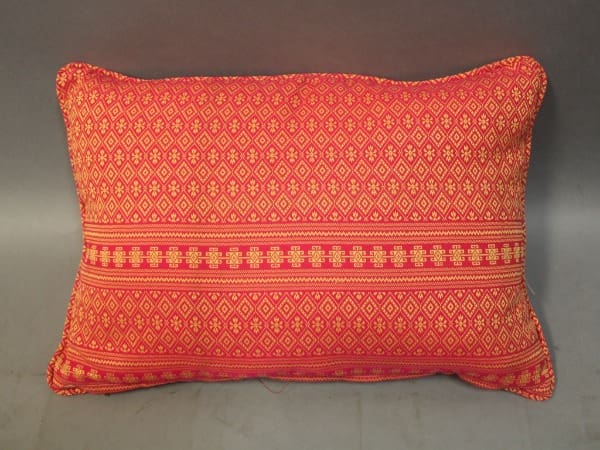 Red patterned rectangular cushion on gray background.