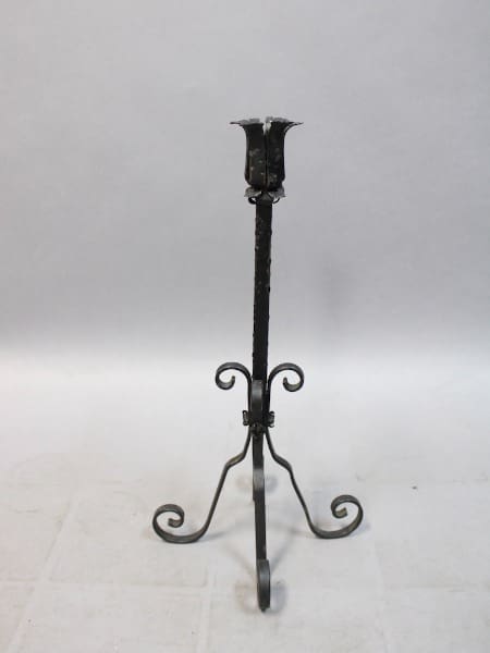 Wrought iron candle holder with ornate design.