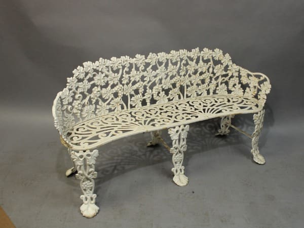 Ornate white wrought iron garden bench.