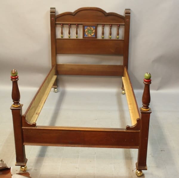 Vintage wooden bed frame with decorative headboard.