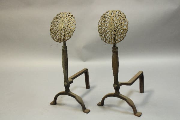 Ornate metal fireplace andirons with intricate design.