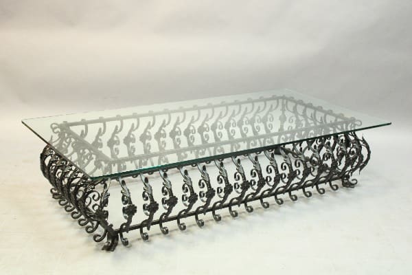 Glass-top table with ornate metal base.
