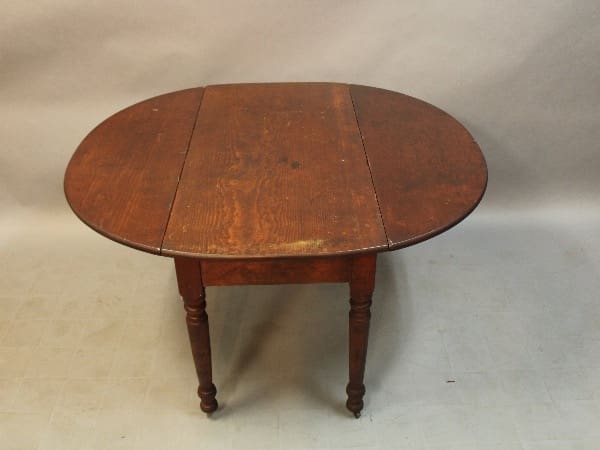 Antique wooden drop-leaf table with legs.