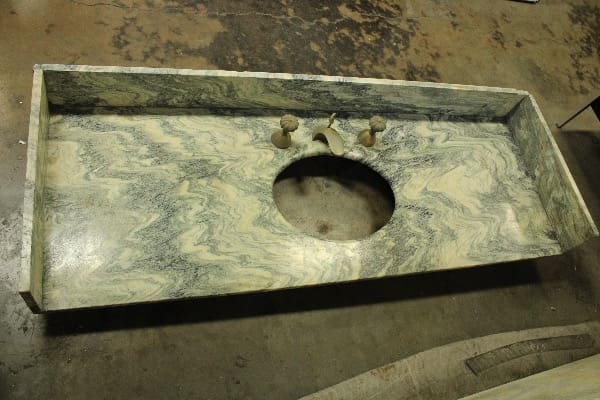 Stone countertop with sink cutout and faucet.