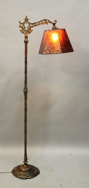 Vintage ornate brass floor lamp lit.