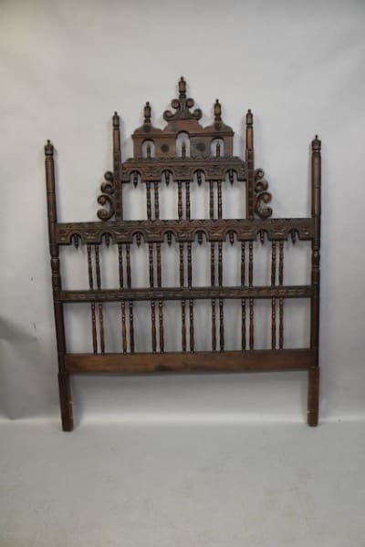 Ornate wooden headboard with intricate carvings.