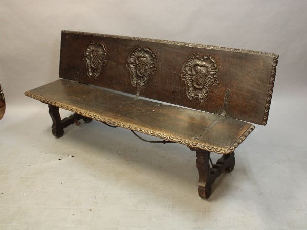 Ornate wooden bench with carved backrest.