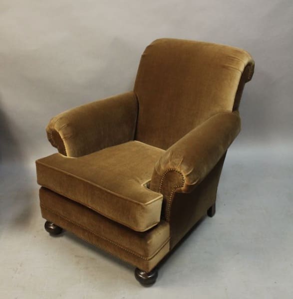 Brown upholstered armchair with wooden legs.