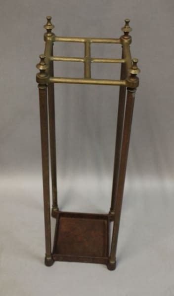 Tall, decorative brass umbrella stand with finials.