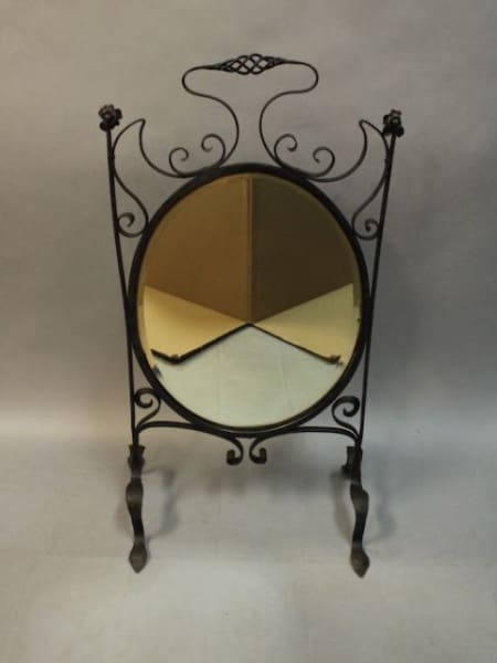 Ornate oval mirror with decorative stand.