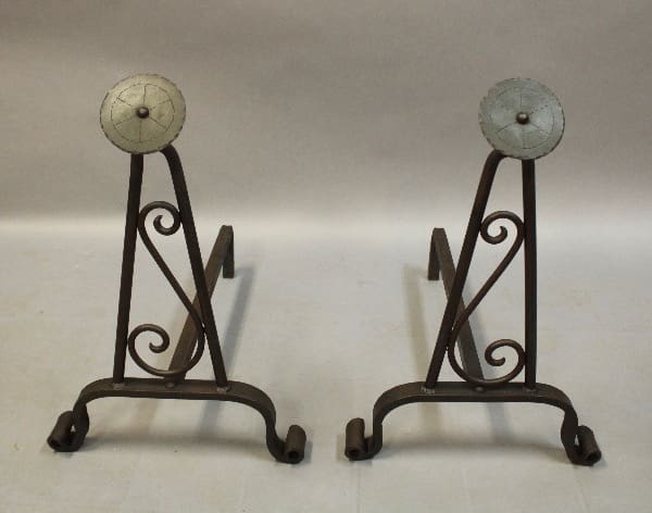 Decorative metal andirons with scroll patterns.
