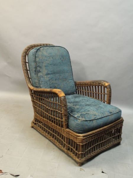 Wicker chair with blue cushions.