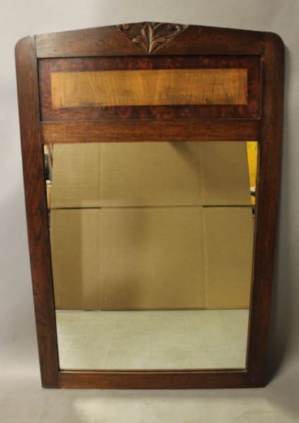 Vintage wooden-framed mirror with decorative top.