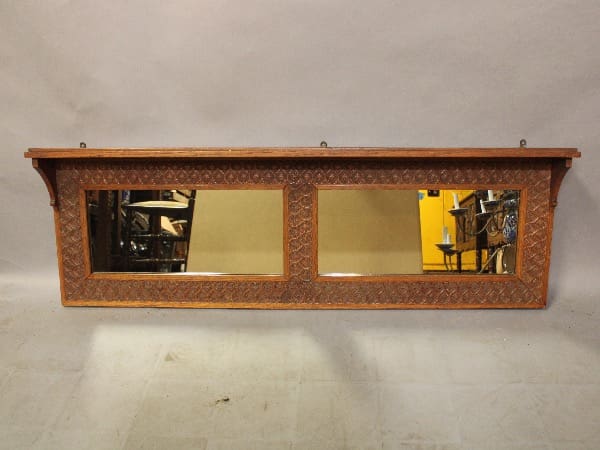 Wooden shelf mirror with intricate carvings.
