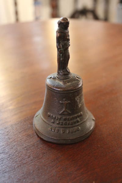 Antique metal bell with figure on top.