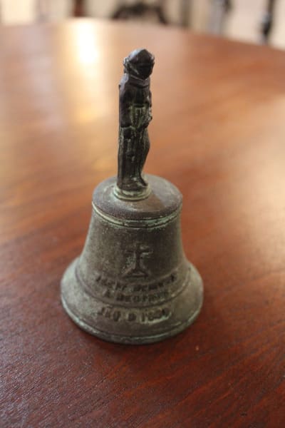 Small bronze bell with a soldier figure.