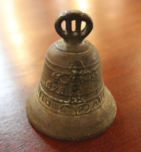 Small decorative bell on wooden surface.