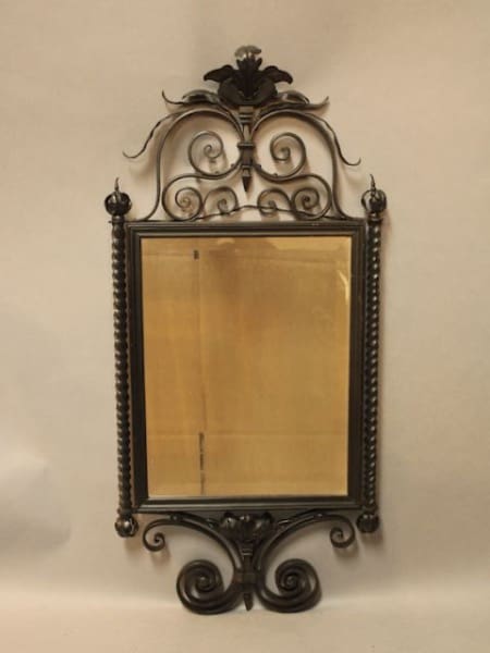 Ornate vintage mirror with decorative metal frame.