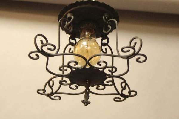 Ornate wrought iron ceiling light fixture.