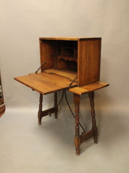 Antique wooden desk with fold-out writing surface.