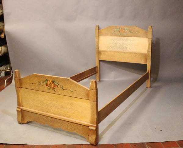 Wooden bed frame with floral carvings.