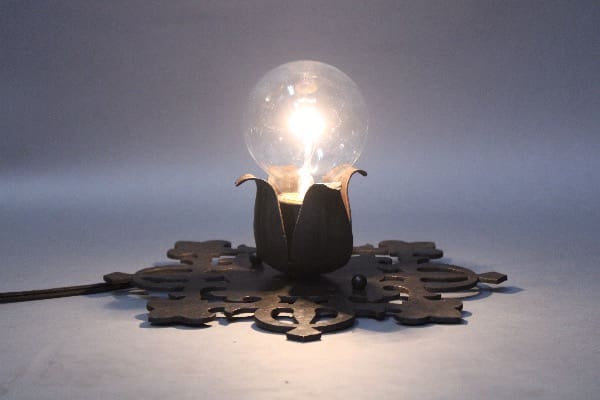 Decorative glowing light bulb on ornate base.