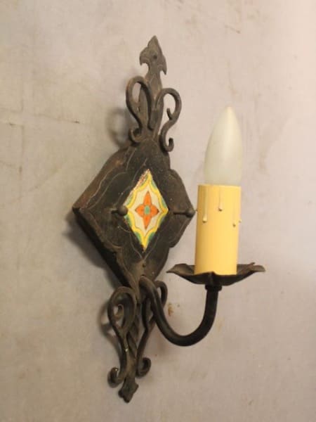 Ornate wall sconce with candle-shaped bulb.