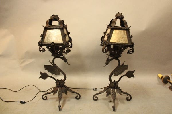 Two ornate wrought iron lamps with cords.