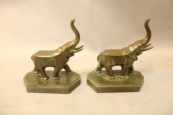 Two brass elephant bookends on display.