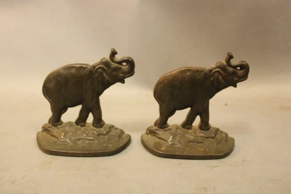 Two elephant figurines on a flat surface.