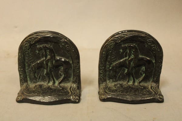 Two bronze horse bookends with ornate design.