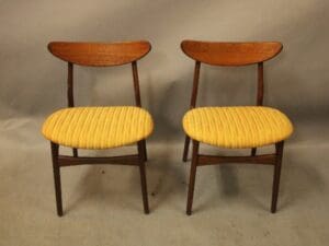 Two wooden chairs with yellow seats.
