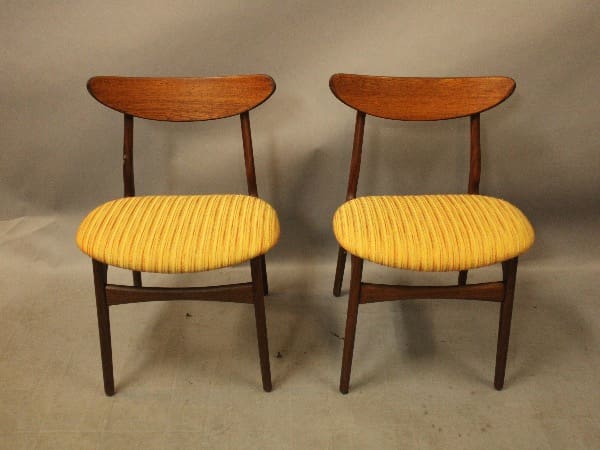 Two wooden chairs with yellow seats.