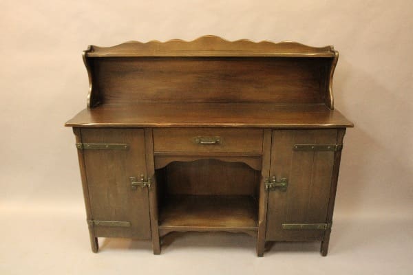Wooden sideboard with cabinets and shelf.