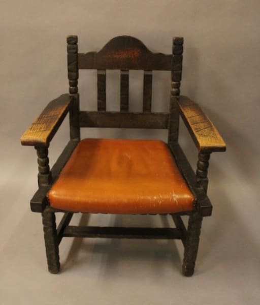 Wooden chair with orange cushioned seat.