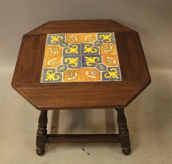 Wooden table with colorful tiled top.