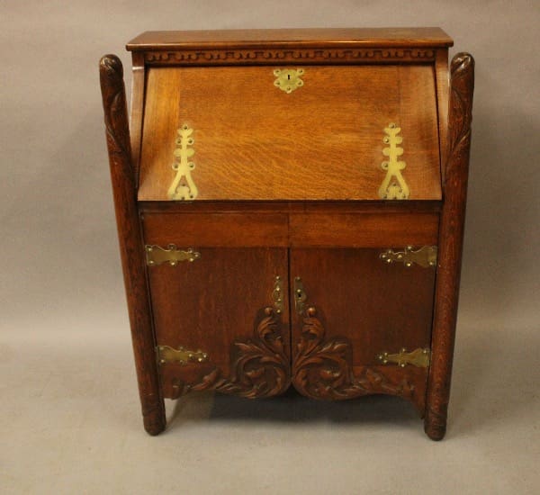 Antique wooden writing desk with ornate carvings.