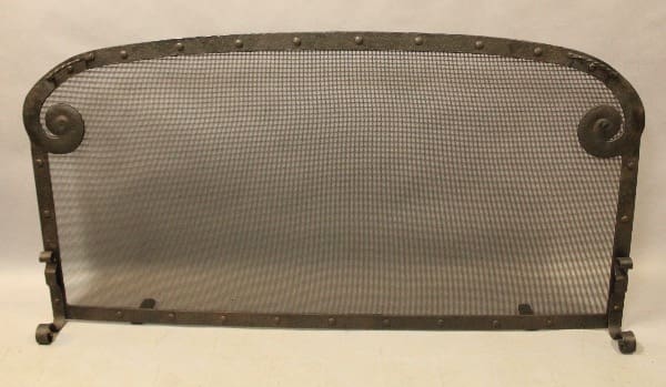 Vintage metal fireplace screen with mesh design.