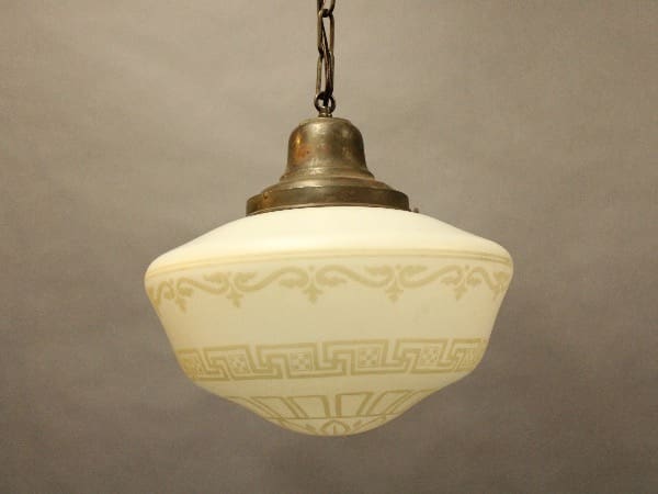 Vintage pendant light with ornate glass shade.