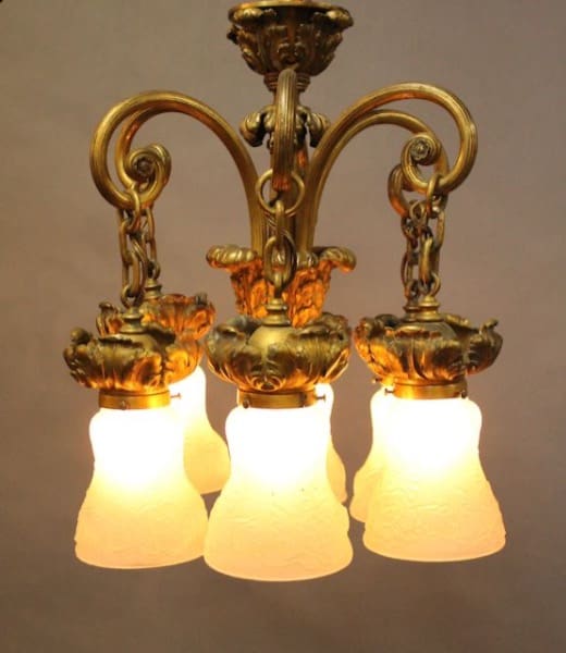 Antique brass chandelier with glowing lights.