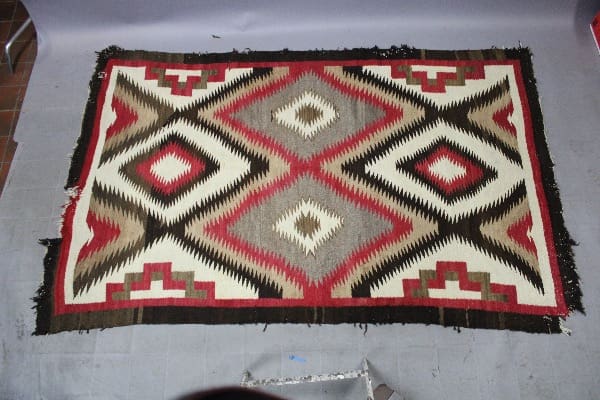 Geometric patterned rug with red and brown.