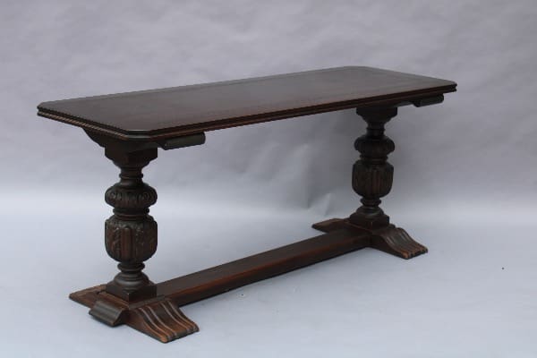 Vintage wooden table with ornate pedestal legs.