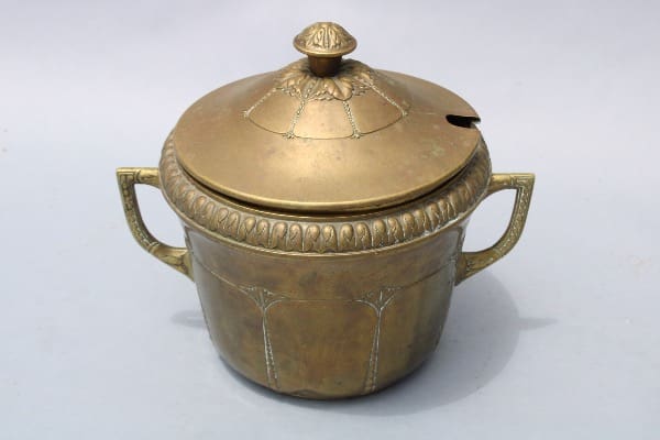 Antique brass pot with ornate lid.