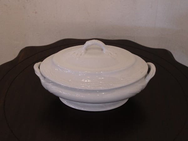 White ceramic dish with lid on table.