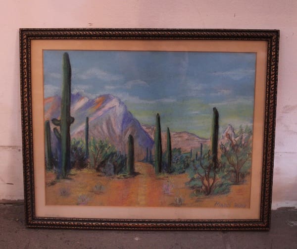 Framed painting of desert landscape with cacti.