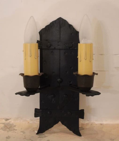 Black vintage wall sconce with two candles.