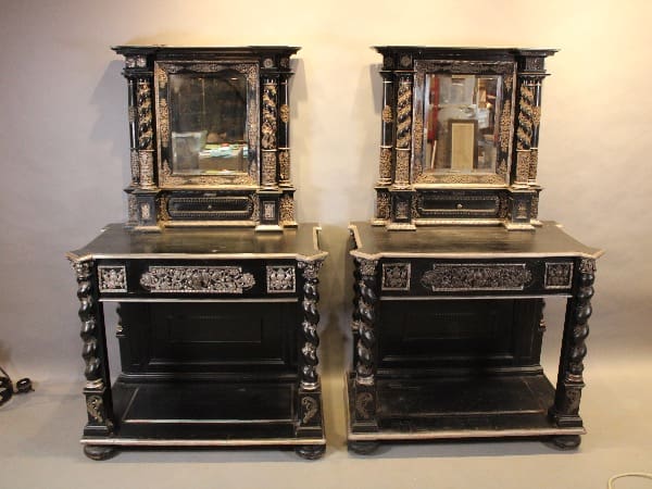 Antique black wooden cabinets with ornate mirrors.