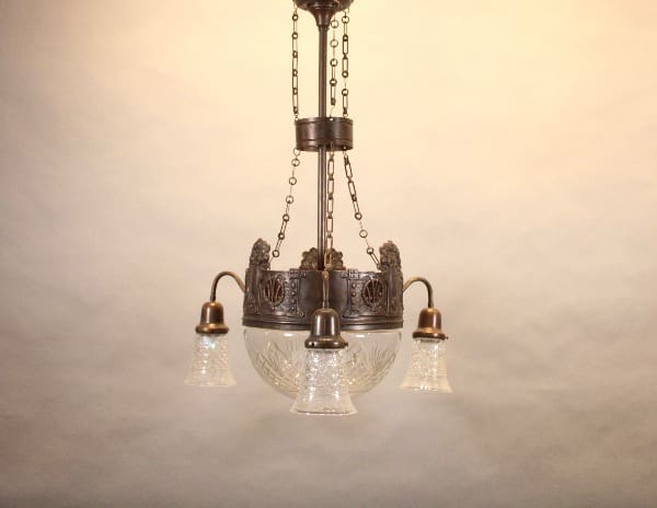 Vintage chandelier with ornate metalwork and glass.