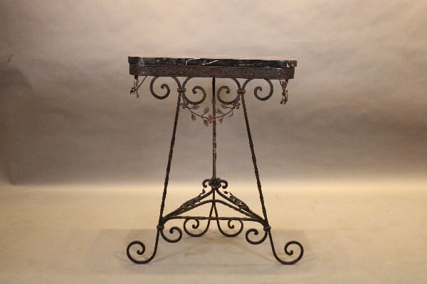 Ornate wrought iron table with marble top.