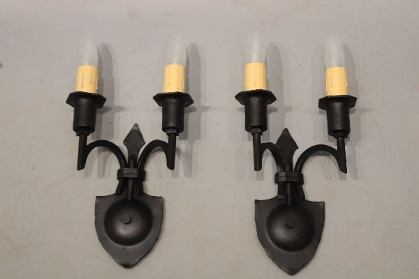 Black metal wall sconces with candle bulbs.